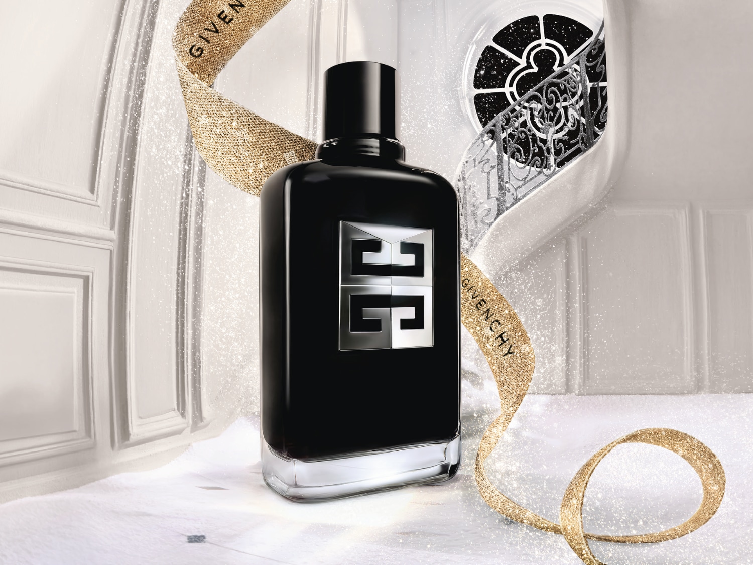 Schwarzer Givenchy-Flakon mit silbernem Logo, umgeben von einem goldenen Band mit dem Schriftzug 'Givenchy', vor einem eleganten, weißen Hintergrund.