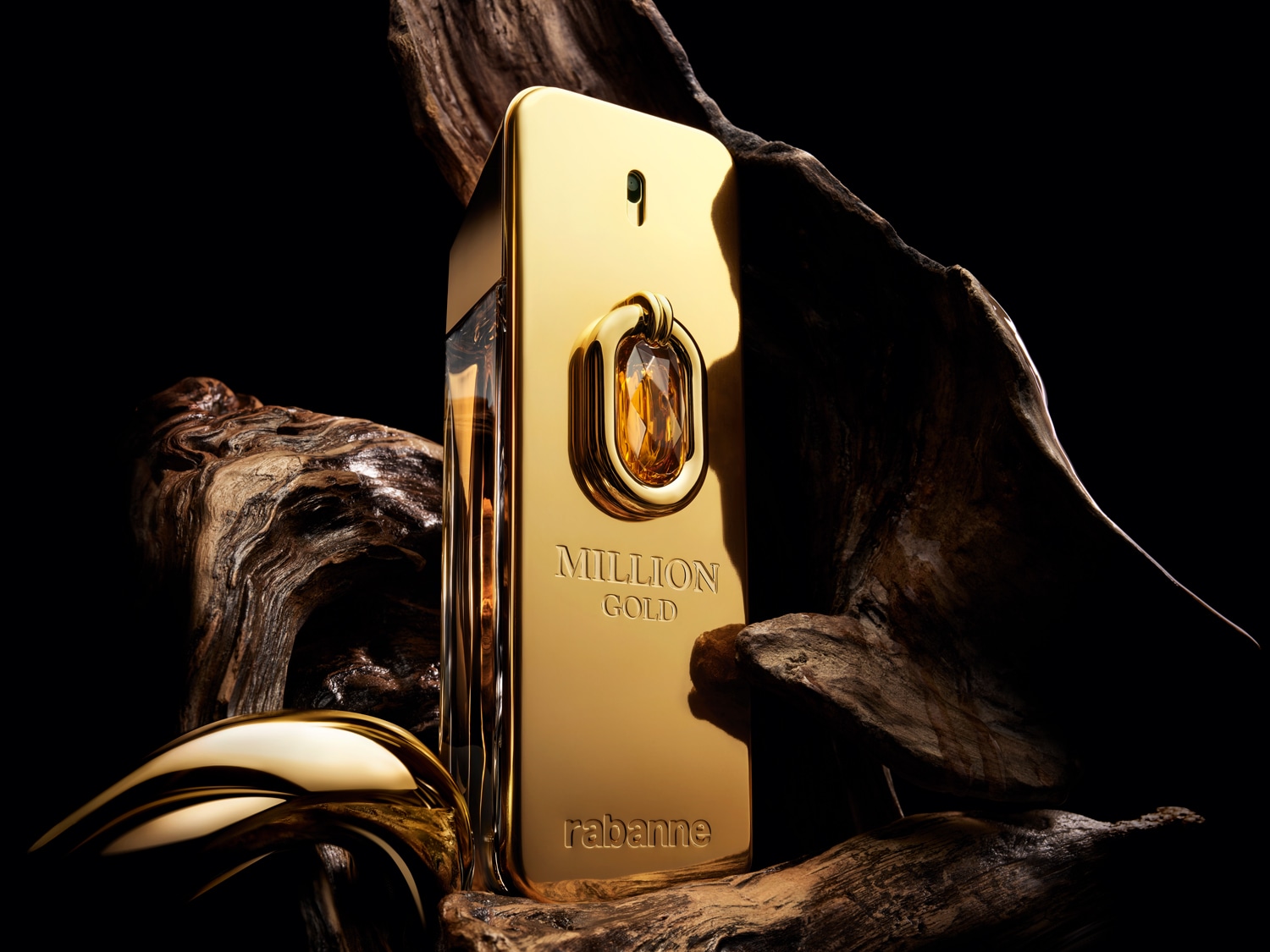 A Paco Rabanne 1 Million Gold parfüm üvegének közeli képe, arany színben, fás jegyekkel körülvéve, luxust és kifinomultságot sugározva.