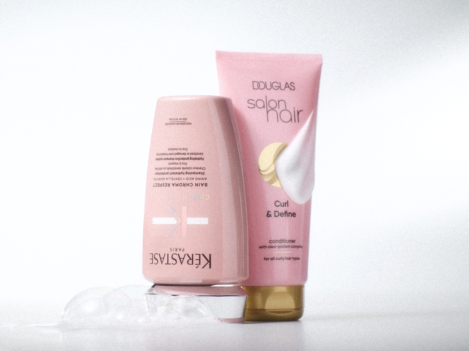 Rosa Farbtöne dominieren bei diesen Haarprodukten: Kérastase Bain Chroma Respect Shampoo und Douglas Salon Hair Curl & Define Conditioner versprechen Pflege und Definition für lockiges Haar.