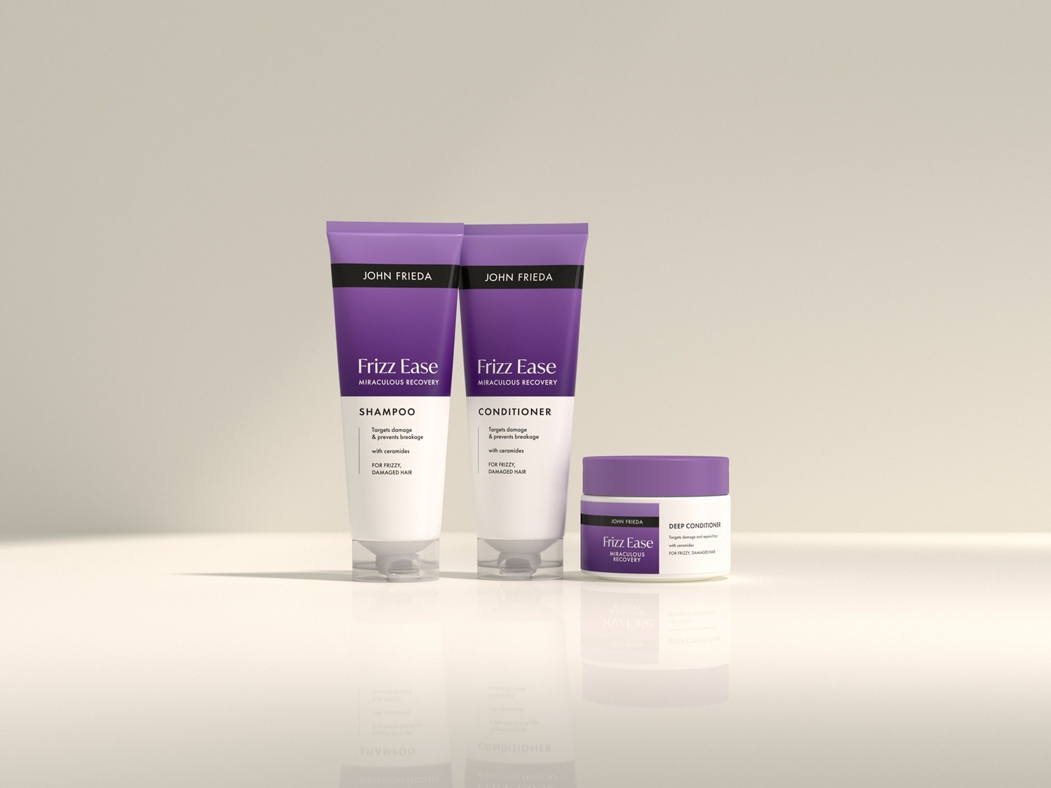 Trio vlasové péče John Frieda Frizz Ease Miraculous Recovery: šampon, kondicionér a hloubkový kondicionér v bílo-fialových obalech, které cílí na poškození a lámavost vlasů.