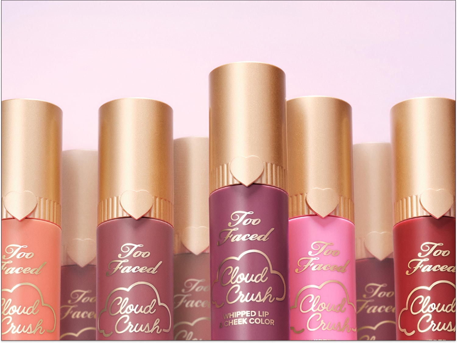 Découvrez le Cloud Crush de Too Faced, un fard à joues et à lèvres fouetté disponible dans une gamme de teintes vibrantes, présentées dans des tubes élégants avec des bouchons dorés en forme de cœur.