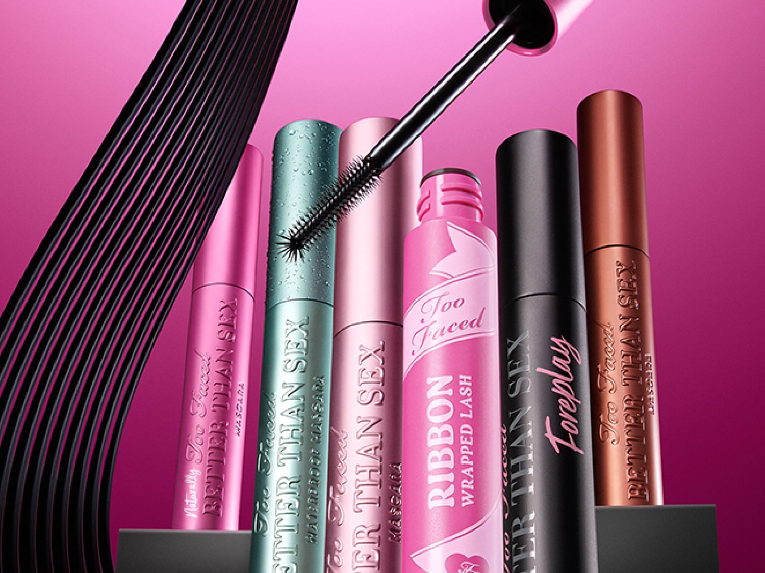 Découvrez la gamme de mascaras Too Faced, incluant Better Than Sex en versions naturelle, waterproof et Foreplay, ainsi que Ribbon Wrapped Lash, présentés dans des emballages roses, turquoise, noirs et bronze.