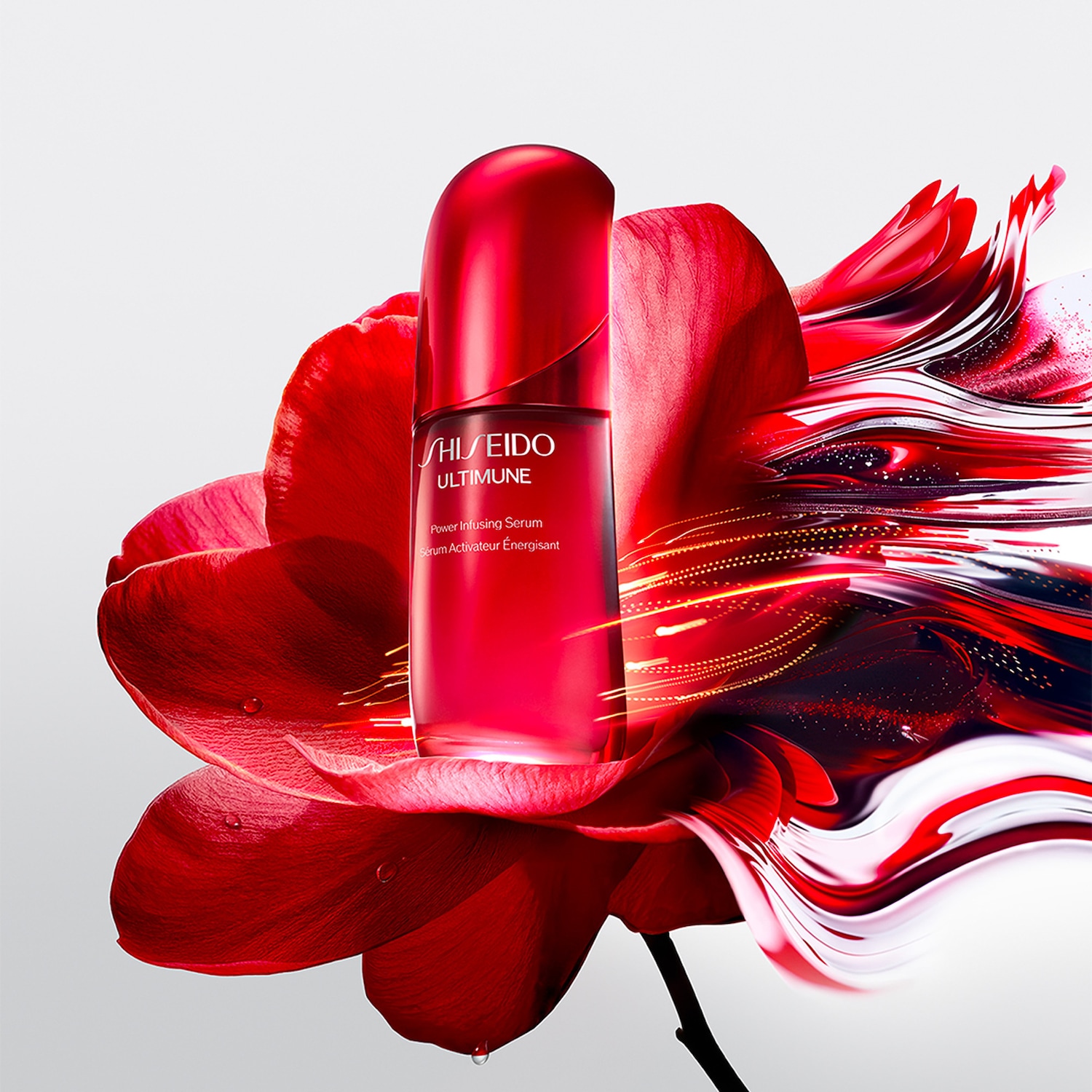 Siero attivatore energetico Shiseido Ultimune in flacone rosso lucido, adagiato su un fiore rosso intenso con dettagli grafici che ne esaltano la luminosità.