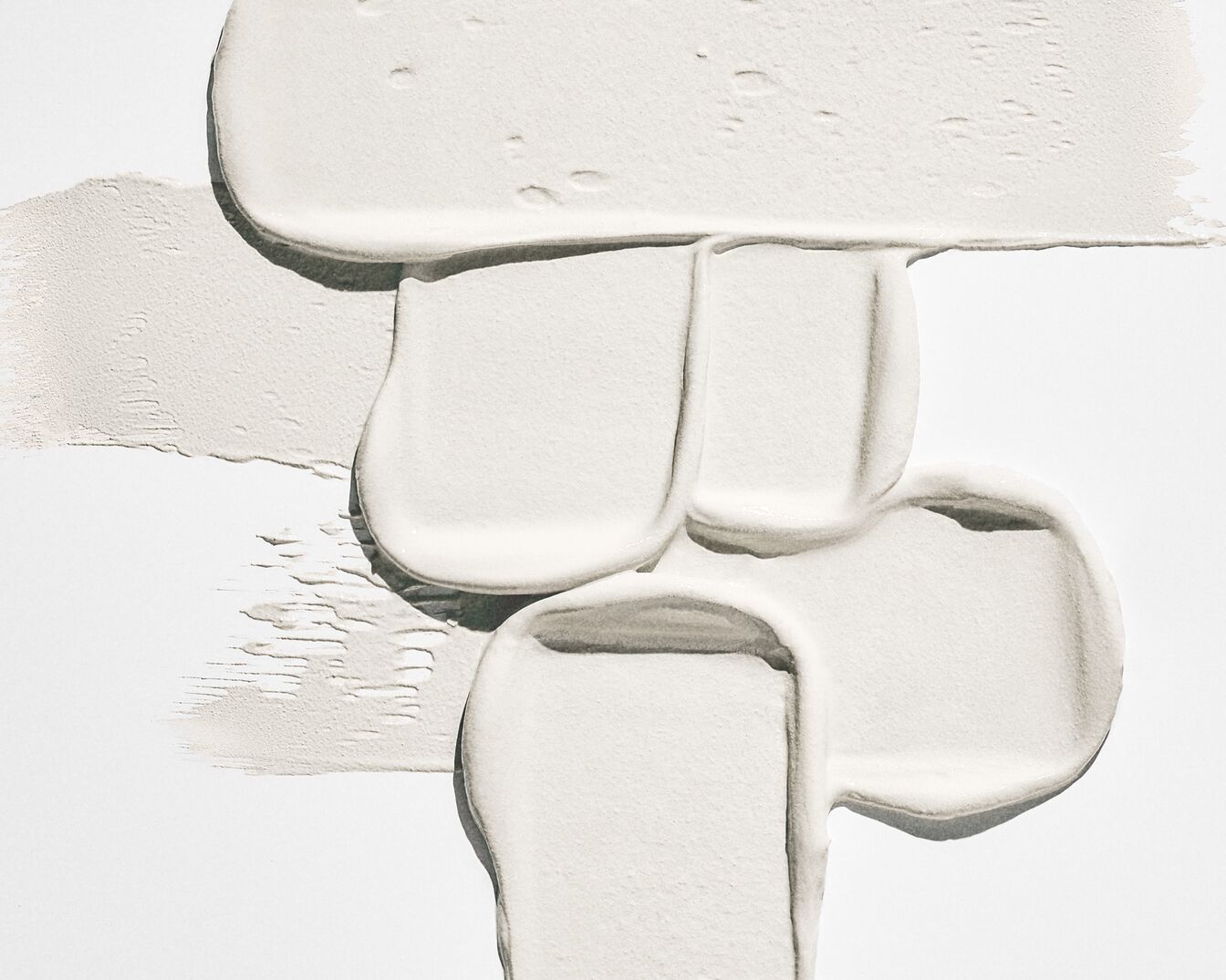 Kremowa konsystencja kosmetyku w odcieniach bieli, idealna do pielęgnacji i ochrony skóry.