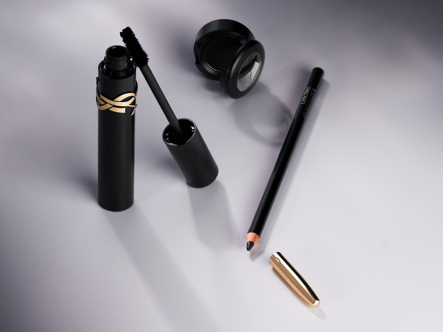 Entdecke das schwarze Mascara mit goldener Verzierung, den schwarzen Kajalstift mit goldener Kappe und den schwarzen Lidschatten für einen verführerischen Augenaufschlag.