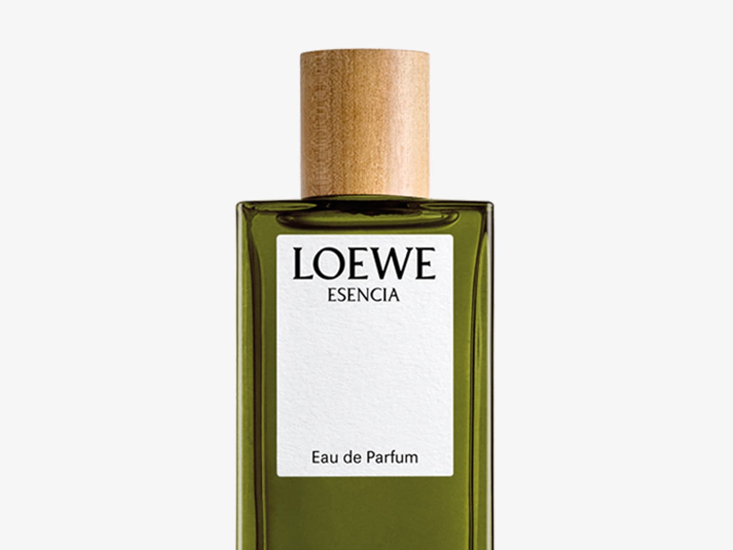 El frasco de vidrio verde oliva de Loewe Esencia Eau de Parfum, con una etiqueta blanca y un tapón de madera claro, irradia una elegancia natural y sofisticada.