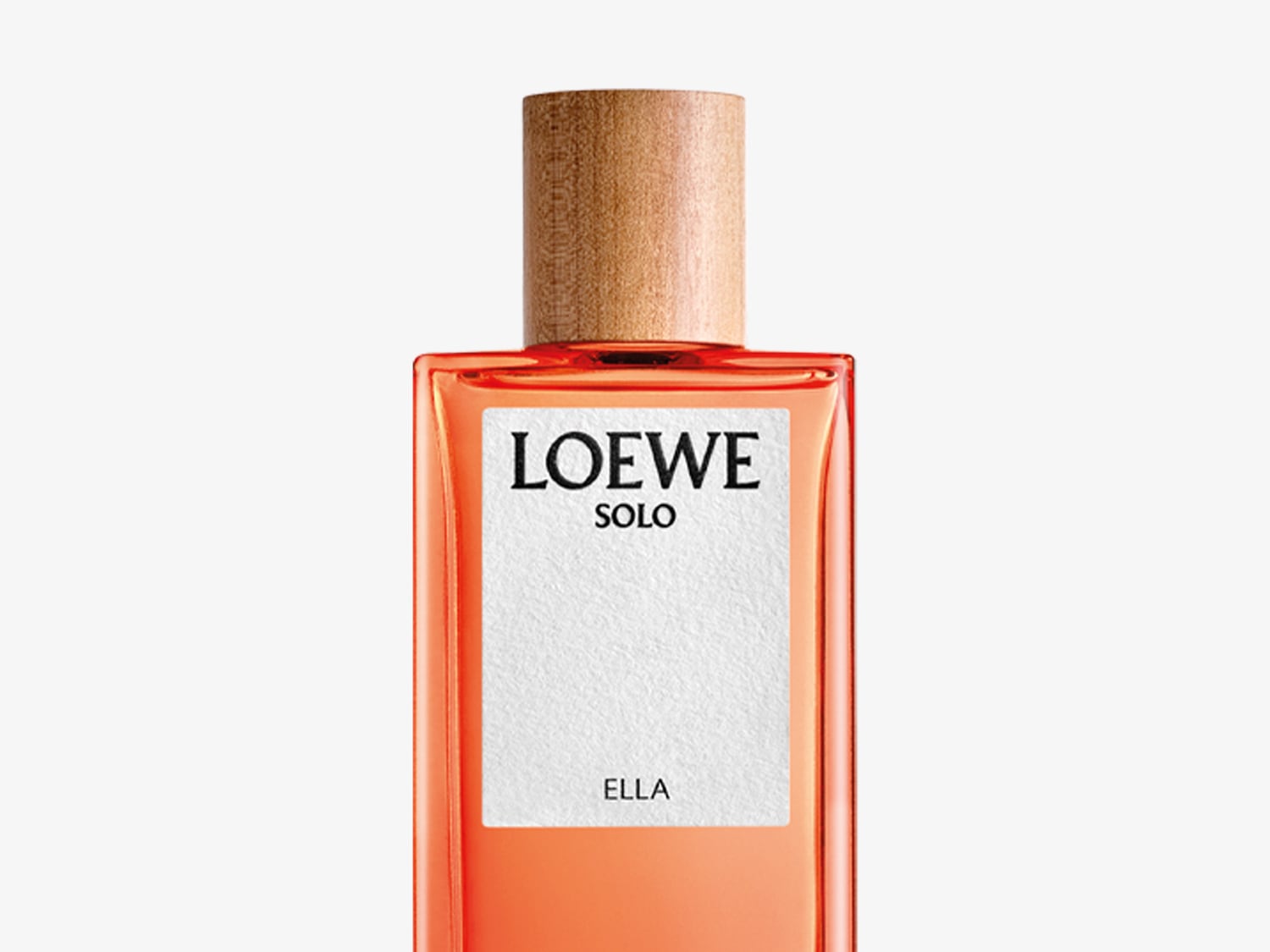 El frasco de perfume Loewe Solo Ella presenta un diseño rectangular con un tapón de madera clara y una etiqueta blanca con letras negras.