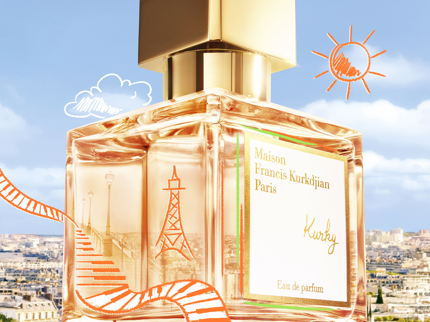 Nahaufnahme des Maison Francis Kurkdjian Paris Kurkdjian Eau de Parfum Flakons mit goldenem Verschluss und Illustrationen von Paris vor einem Hintergrund mit blauem Himmel.
