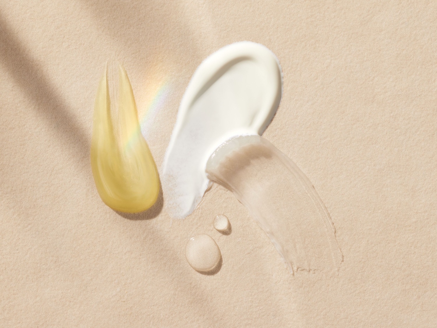 Verschillende texturen van huidverzorgingsproducten, waaronder een gele olie, een witte crème en een transparant serum, liggen op een zandkleurige achtergrond.