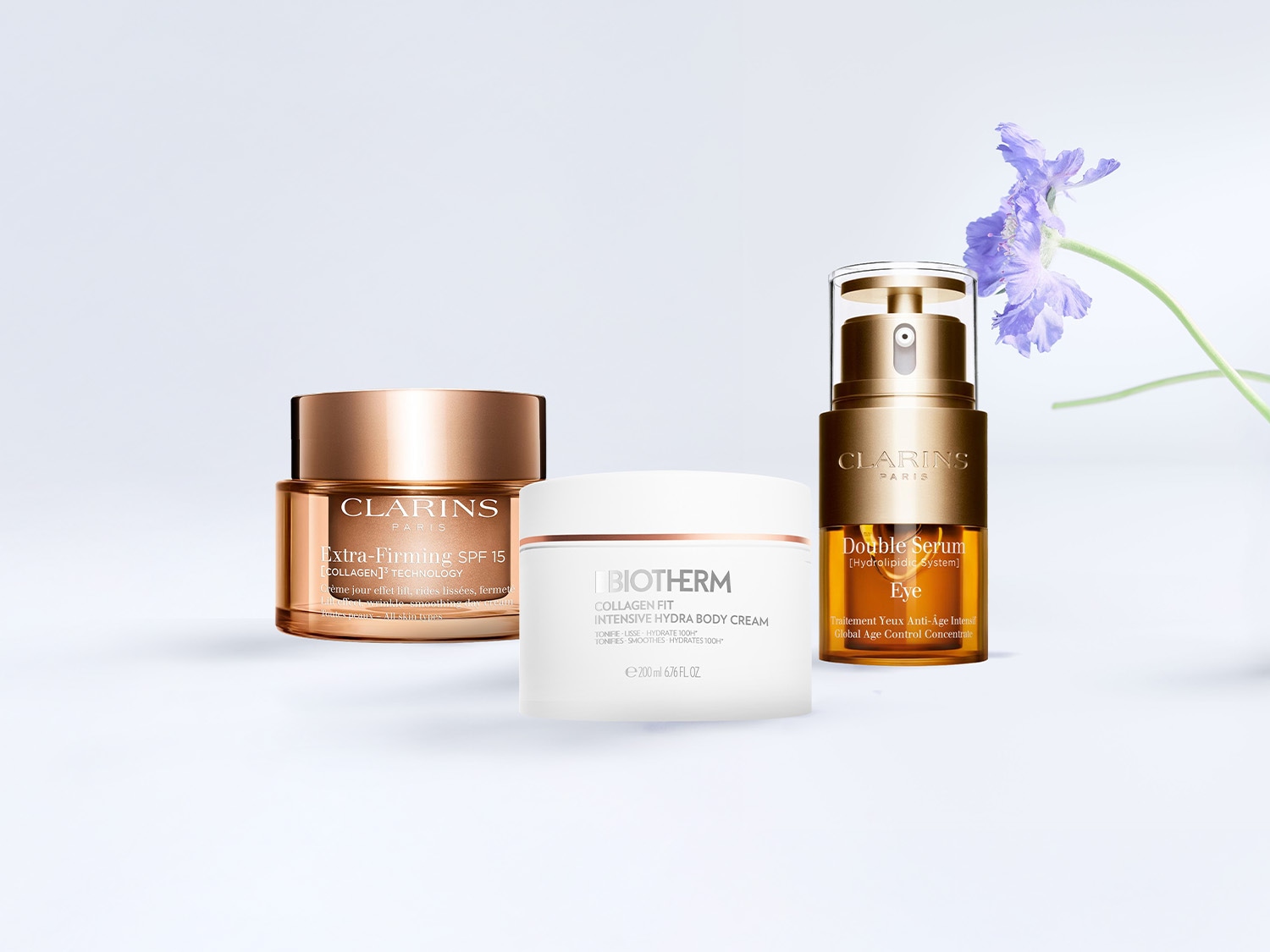 Découvrez les soins Clarins et Biotherm : Crème Extra-Firming SPF 15 dans un pot doré, Sérum Double Eye dans un flacon doré, et Crème Corps Intensive Hydra dans un pot blanc, pour une peau tonifiée et hydratée.