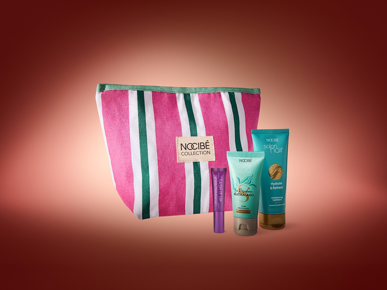Voici une trousse rayée rose et blanche avec des produits Nocibé : un mascara violet Lash It Up, une crème pour les mains Home Spa et un shampooing hydratant Salon Hair.