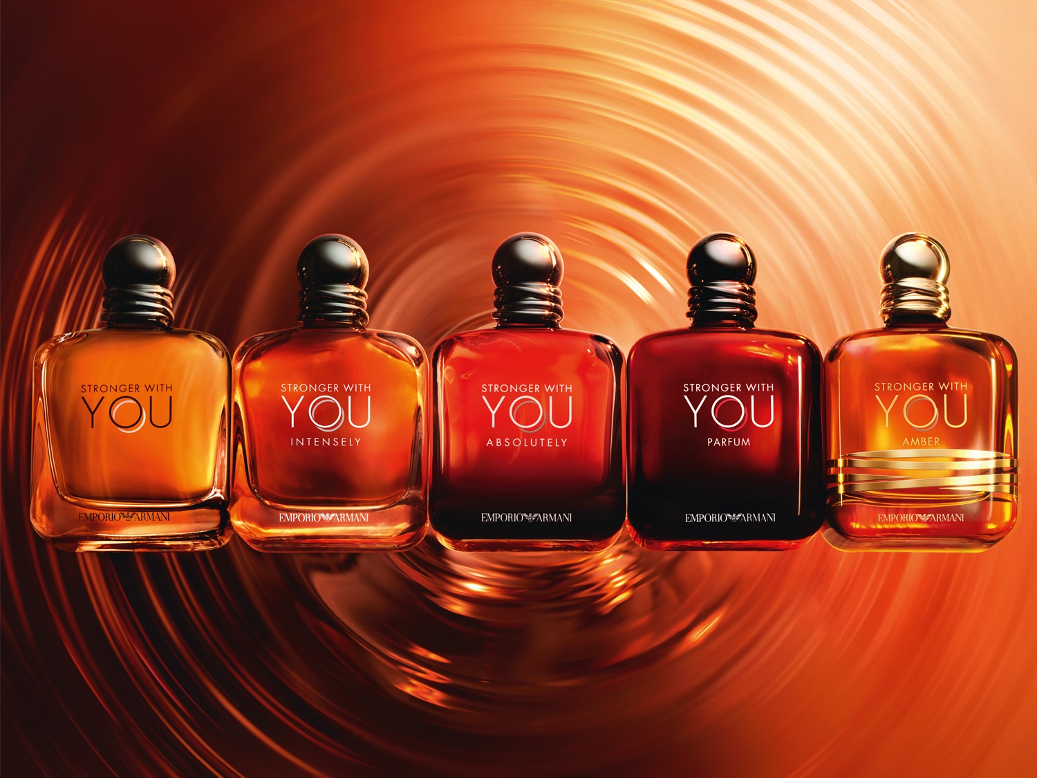 Öt különböző színű és illatú Emporio Armani Stronger With You parfümös üveg látható, melyek a borostyán különböző árnyalataiban pompáznak.