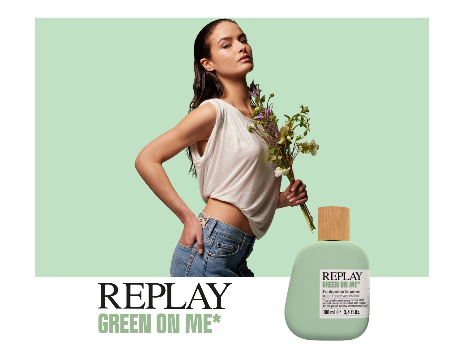 Een vrouw met een boeket bloemen staat naast een fles Replay Green on Me parfum, een geur met duurzame verpakking en natuurlijke ingrediënten.