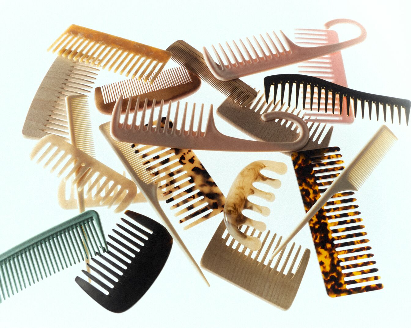 Een verzameling kammen in verschillende kleuren en stijlen, waaronder bruin, zwart, beige en schildpad, liggen door elkaar.