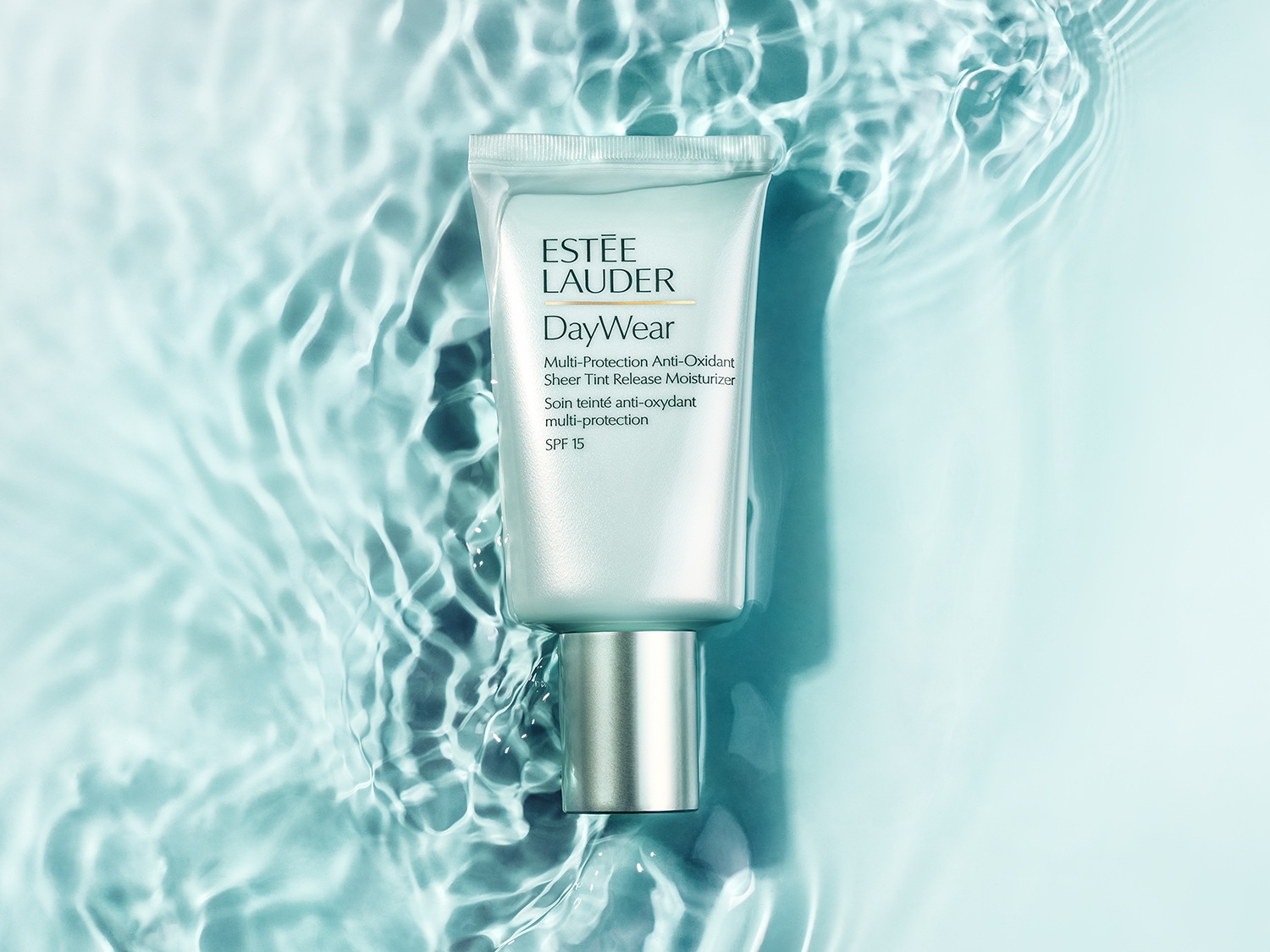 Le tube blanc nacré d'Estée Lauder DayWear offre une protection multi-antioxydante et une hydratation teintée avec un FPS 15, flottant dans l'eau.