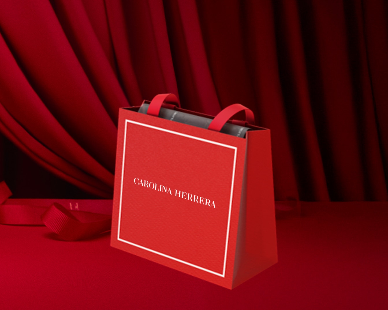 Bolsa de compras roja de Carolina Herrera con asas rojas sobre un fondo rojo, que muestra elegancia y estilo.