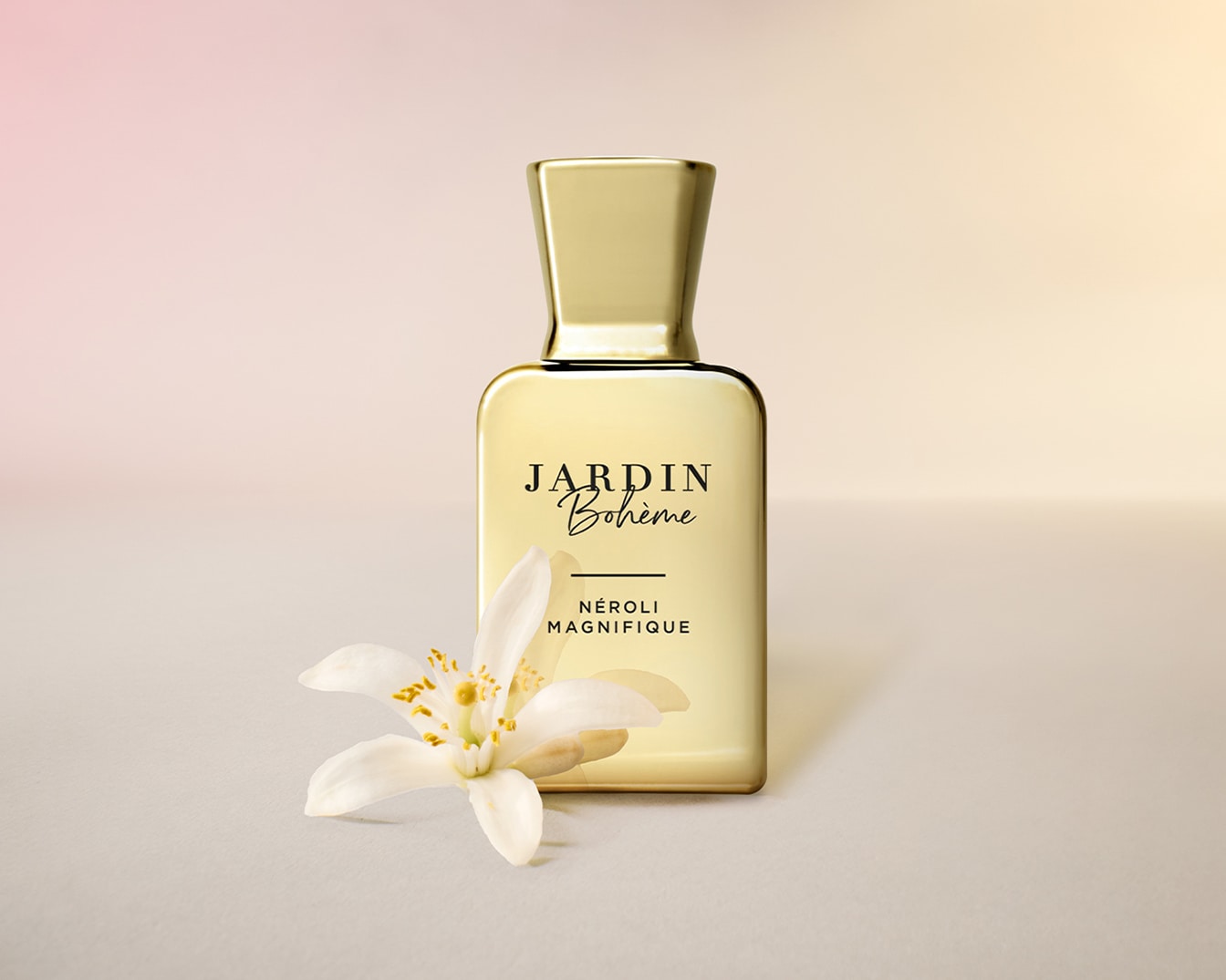Gouden flesje Jardin Bohème Néroli Magnifique parfum met een witte bloem op de voorgrond, voor een frisse en elegante geur.
