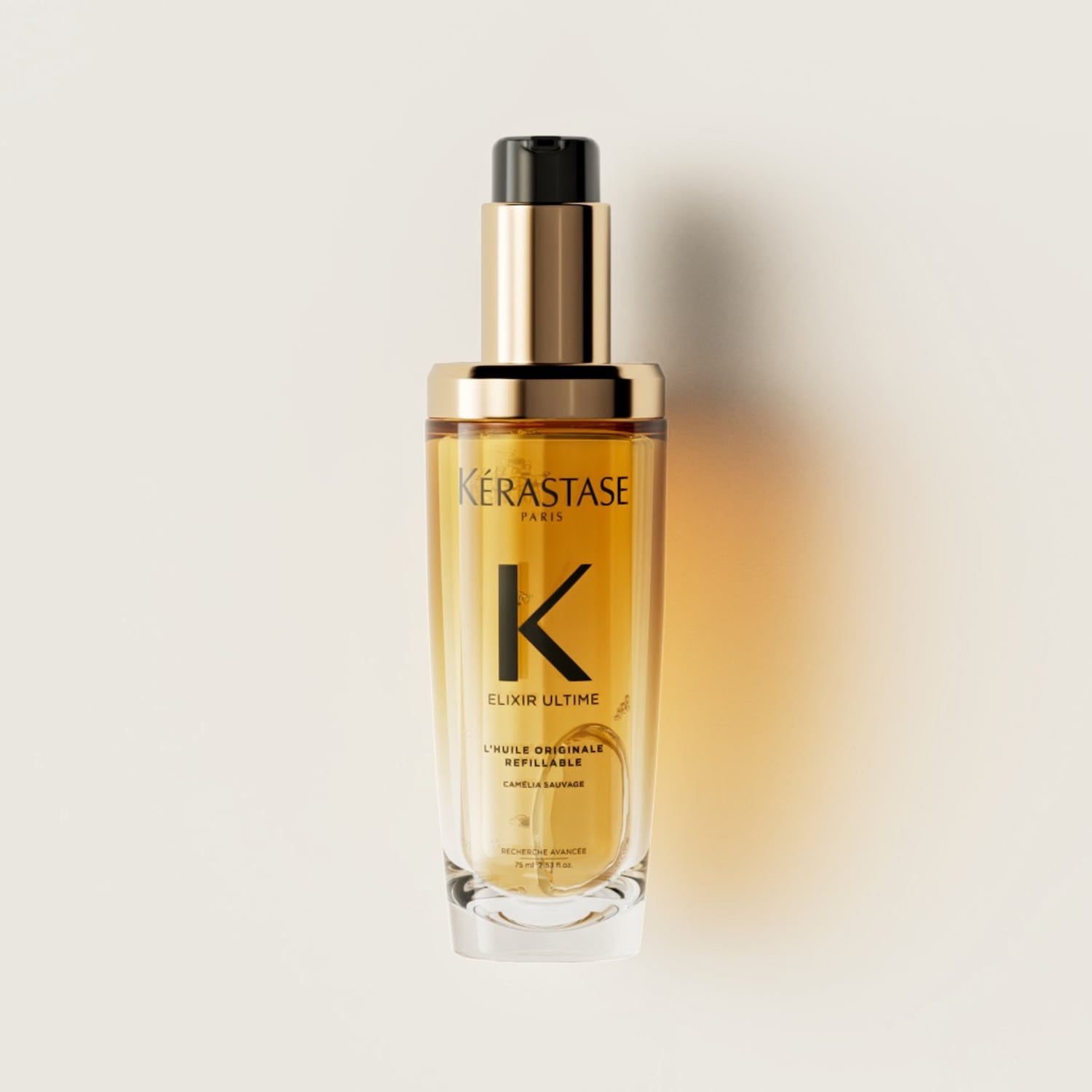 Das Kérastase Elixir Ultime Öl präsentiert sich in einer klaren Glasflasche mit goldenem Verschluss und schwarzem Applikator, gefüllt mit einem goldenen Öl.