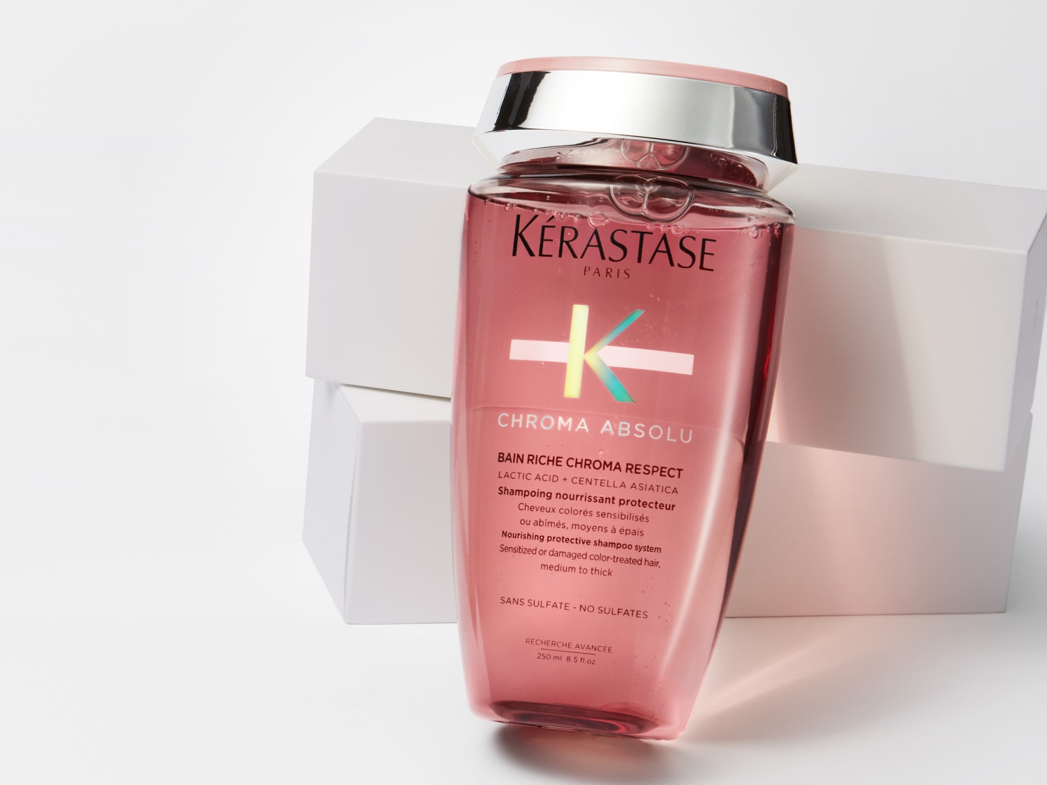 Eine rosafarbene Flasche Kérastase Chroma Absolu Shampoo, das nährende Schutzshampoo für sensibilisiertes oder geschädigtes, coloriertes Haar, mittel bis dick.