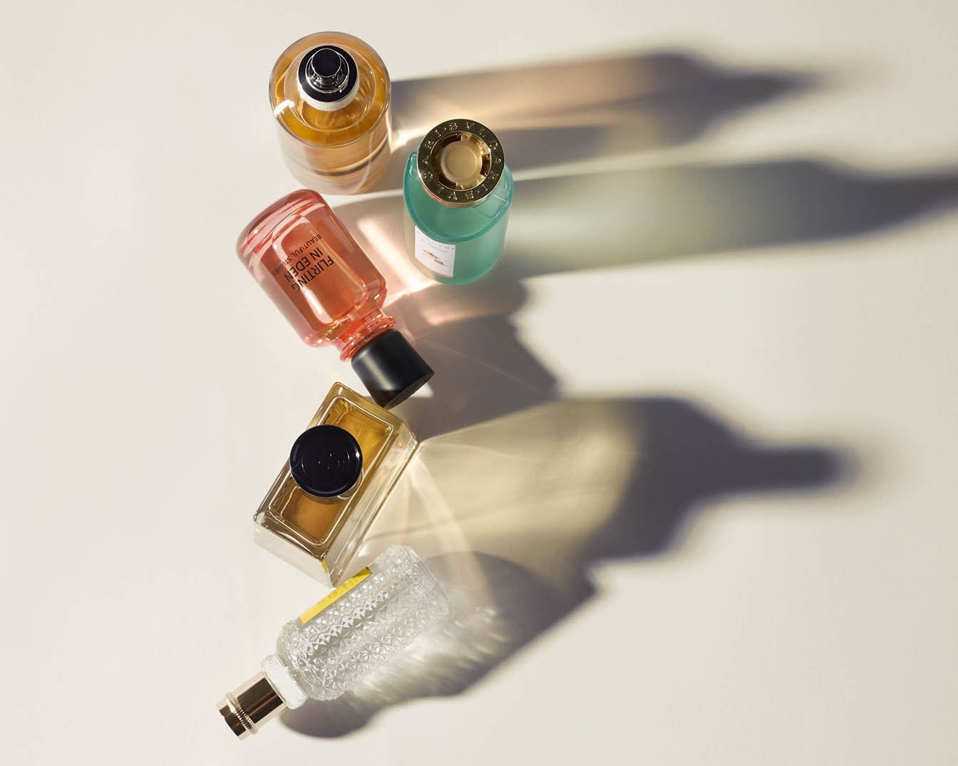 Découvrez une sélection exquise de parfums, chacun dans son flacon unique : ambré, rose, doré, turquoise et transparent.