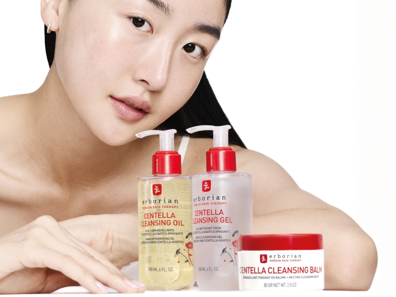 A képen egy fiatal nő látható az Erborian Centella termékeivel, köztük a tisztító olajjal, géllel és balzsammal, amelyek Centella Asiatica-t tartalmaznak a bőrnyugtatáshoz.