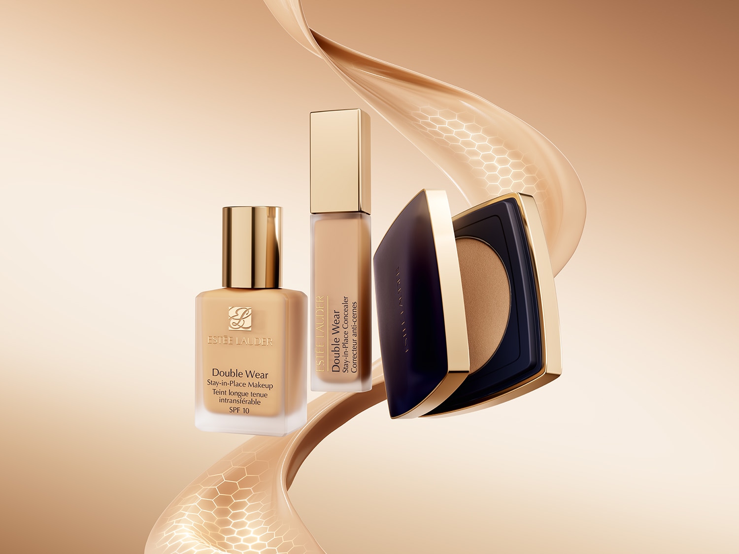 Estée Lauder Double Wear Make-up Produkte: Foundation in einer Glasflasche, Concealer in einem schlanken Behälter und Kompaktpuder in einer marineblauen Dose mit goldenen Akzenten.