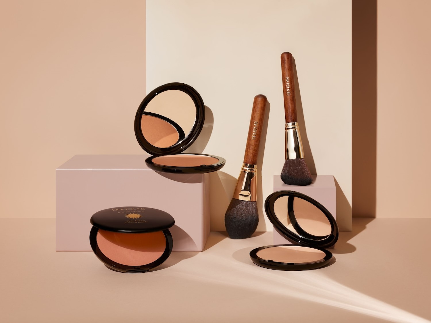 Douglas gezichtspoeder en bronzer met zachte borstels, klaar om je teint te perfectioneren en je natuurlijke schoonheid te accentueren.