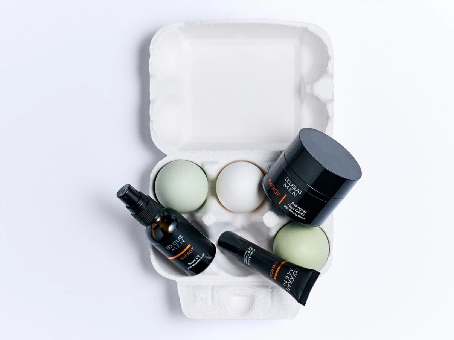 Douglas Men Energy-Serie: Bartöl mit Macadamiaöl, Anti-Aging-Gesichtscreme mit Ginseng-Extrakt und Anti-Aging-Augencreme in einer Eierverpackung.