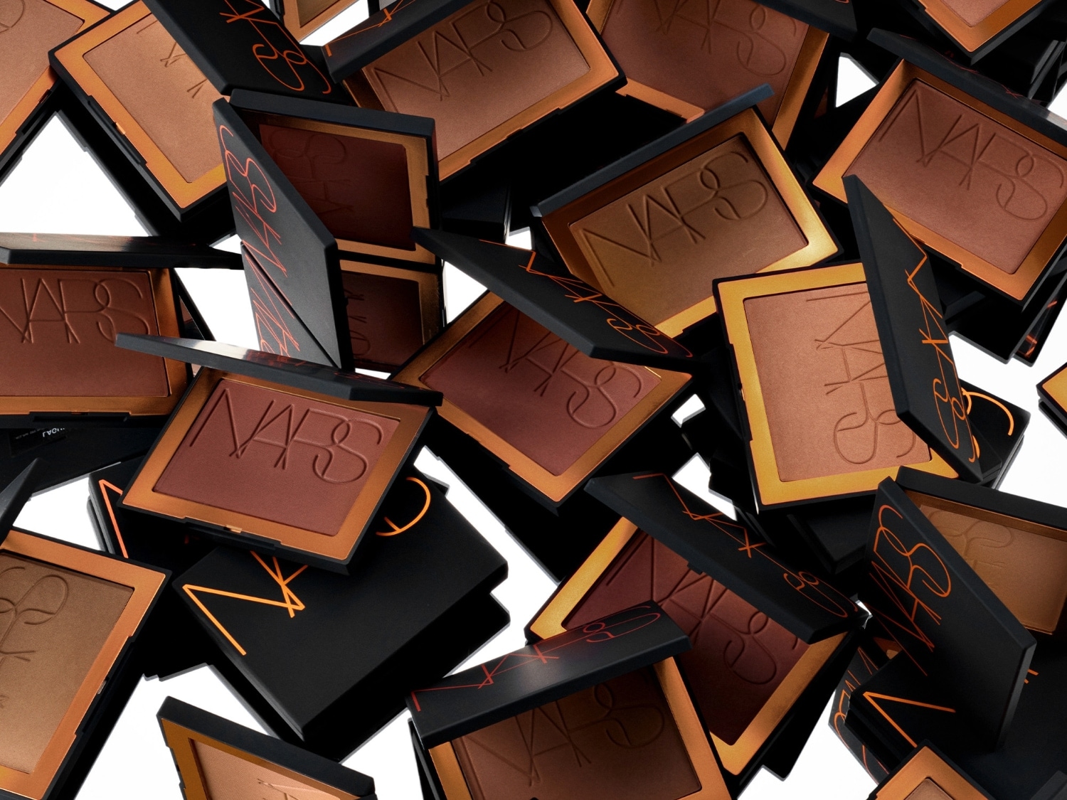Een verzameling NARS bronzers in verschillende tinten, verpakt in zwarte doosjes met oranje letters, klaar om je huid een zonovergoten gloed te geven.