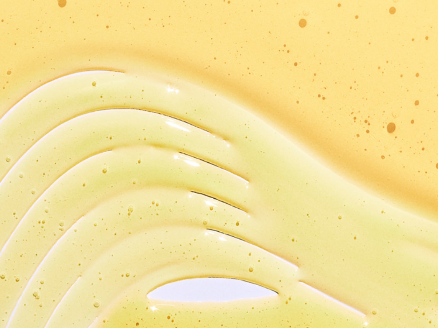 Texture del siero giallo chiaro con bollicine, che mostra la consistenza liscia e idratante del prodotto.