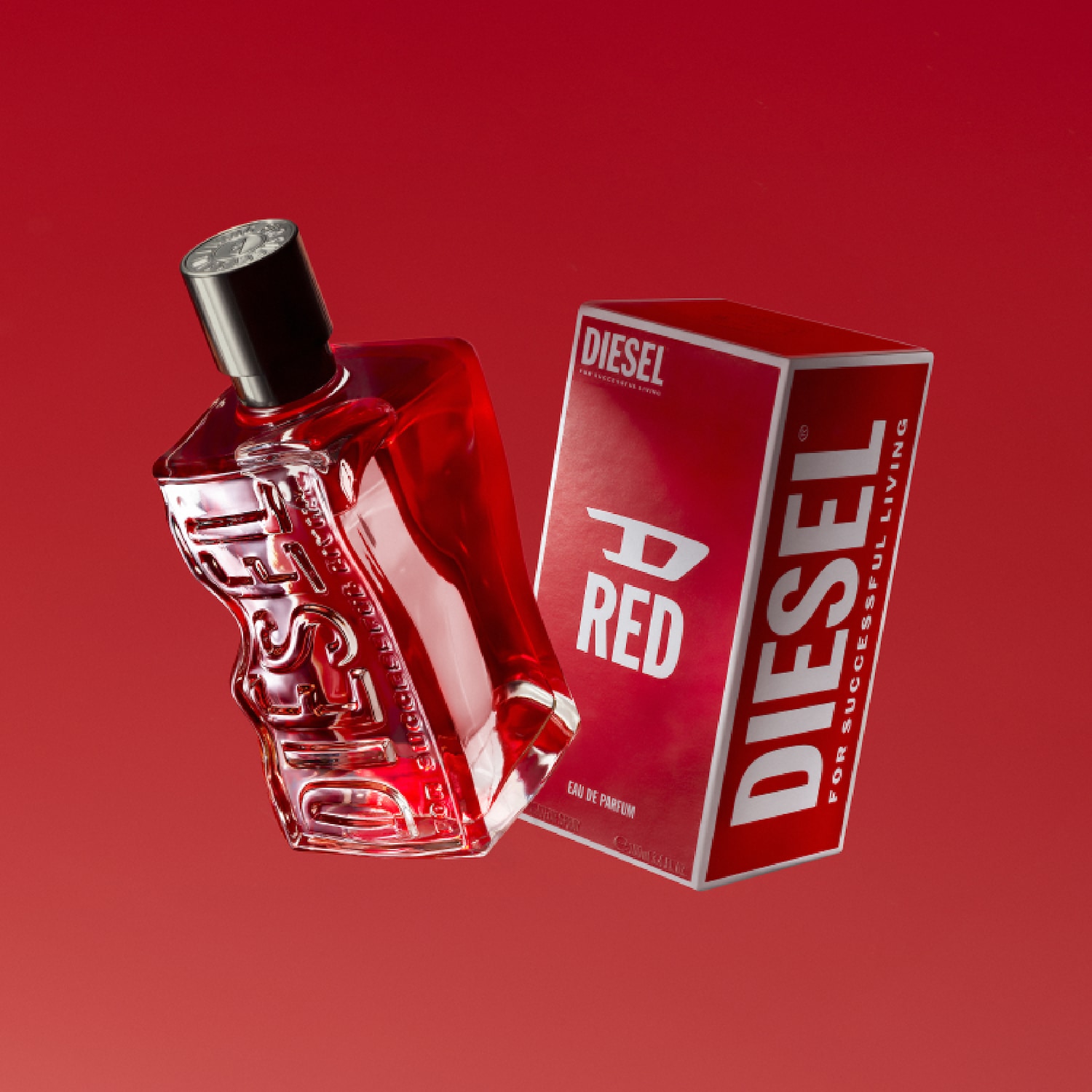 "Une bouteille de parfum rouge de forme unique, avec le mot 'DIESEL' en relief sur le côté, repose sur le côté gauche d'un fond rouge vif. À sa droite se trouve une boîte de parfum rouge et blanche correspondante, avec les mots 'DIESEL' et 'RED' écrits dessus, et la mention 'FOR SUCCESSFUL LIVING'