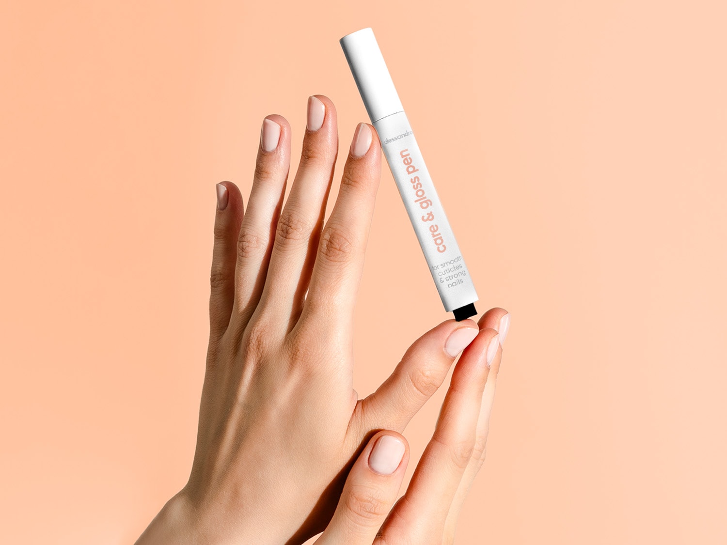 Nahaufnahme einer Hand, die einen weißen Nagelhautstift von Alessandro hält, der für glatte Nagelhaut und starke Nägel wirbt.