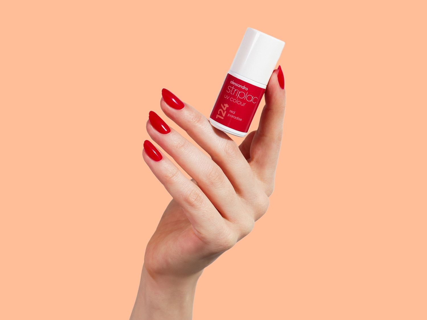 Eine Hand hält eine Flasche Alessandro Striplac UV-Farbe in Rot mit der Nummer 124 Red Paradise, passend zu den lackierten Nägeln.