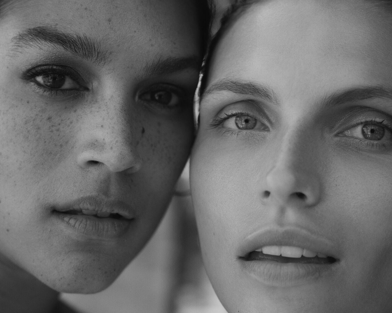 Dviejų moterų portretas juodai baltas, vienos oda su strazdanomis, kitos - lygi.