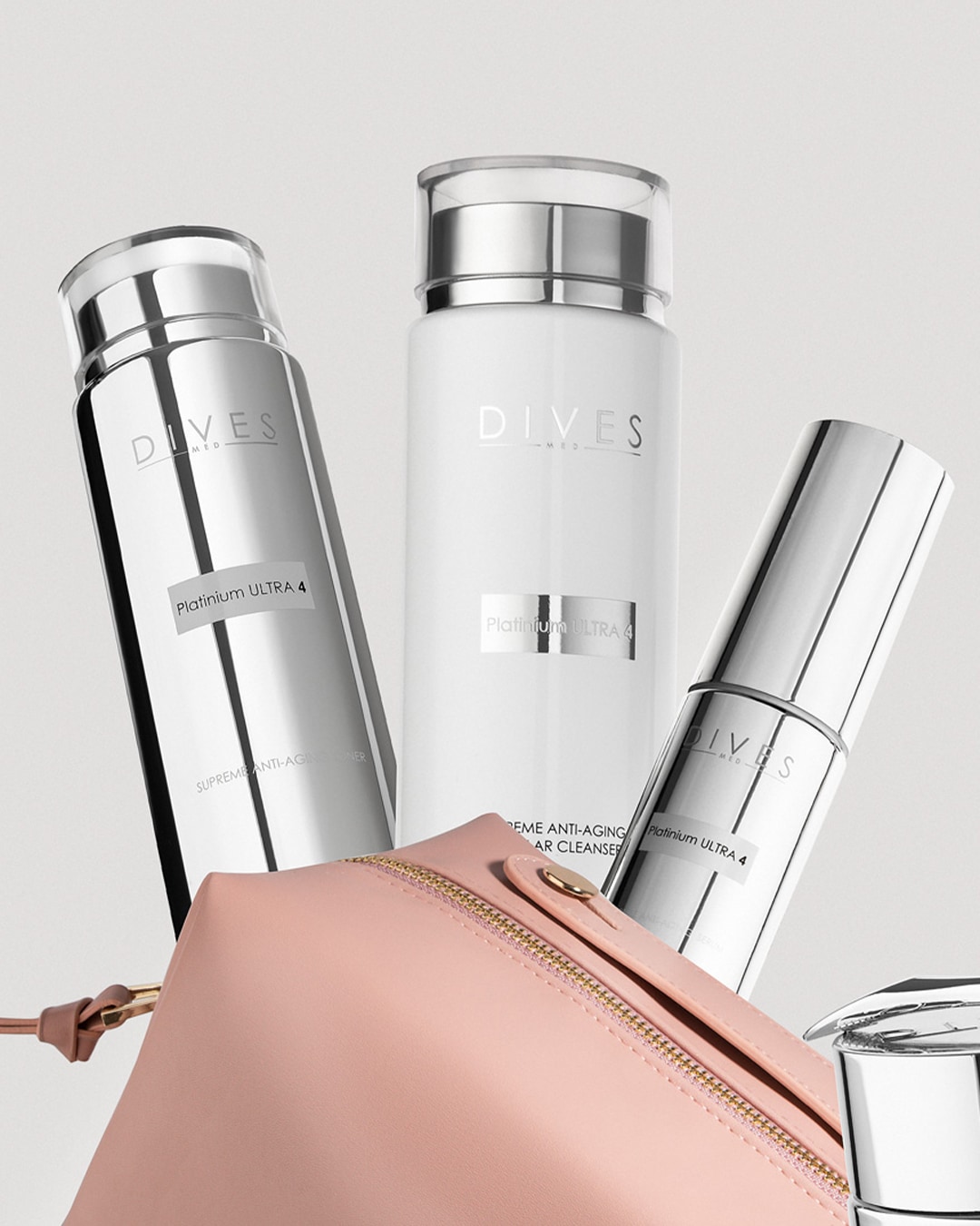 Trzy srebrno-białe butelki Dives Platinium ULTRA 4, w tym Supreme Anti-Aging Toner i żel do mycia twarzy, ustawione obok różowej kosmetyczki.