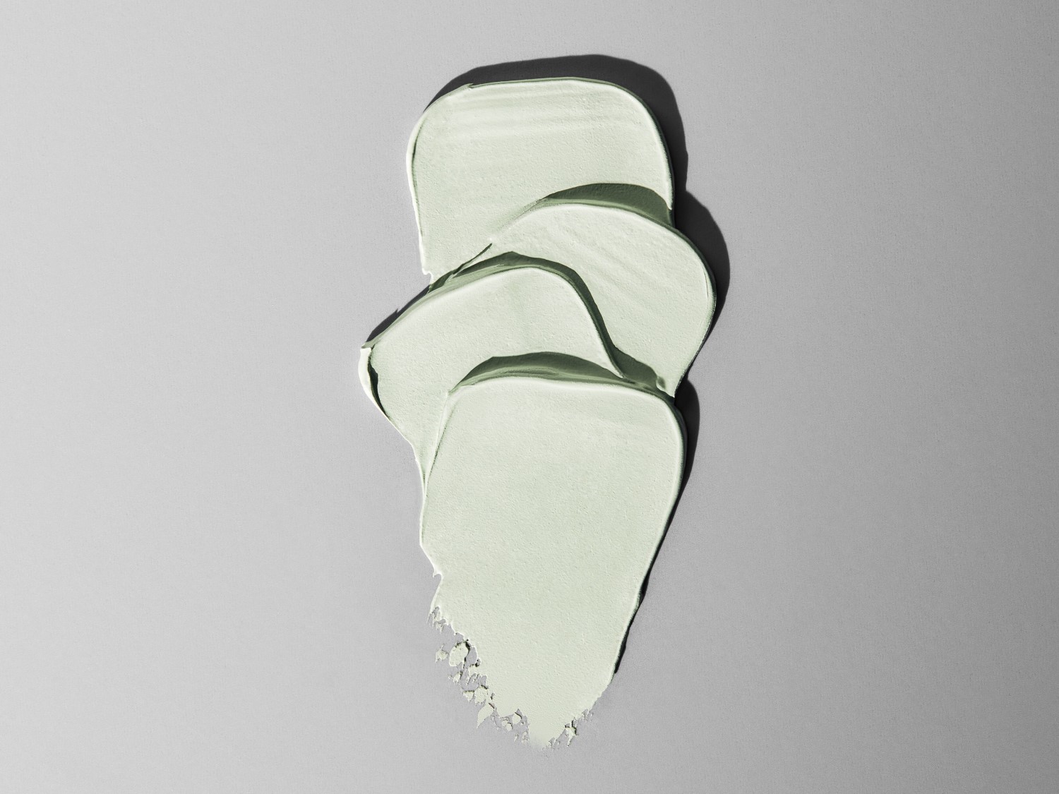 Aquí hay una muestra de mascarilla facial verde claro con una textura suave y cremosa, ideal para el cuidado de la piel.