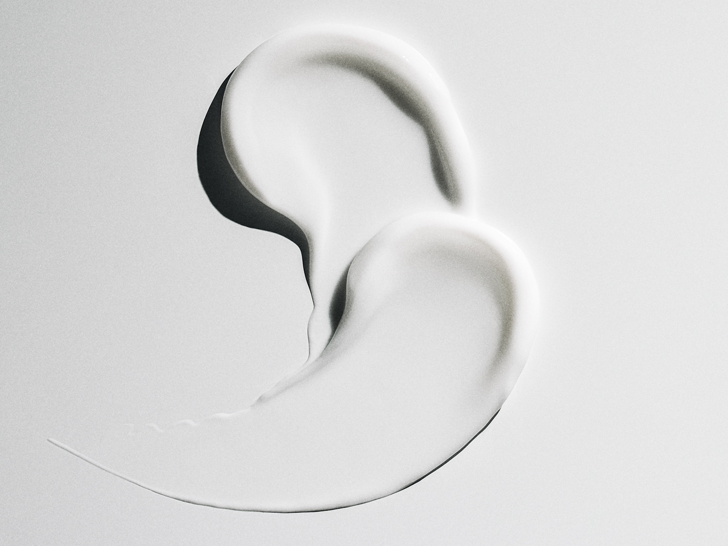 Ecco un primo piano di una crema bianca liscia, che mostra la sua consistenza ricca e vellutata.