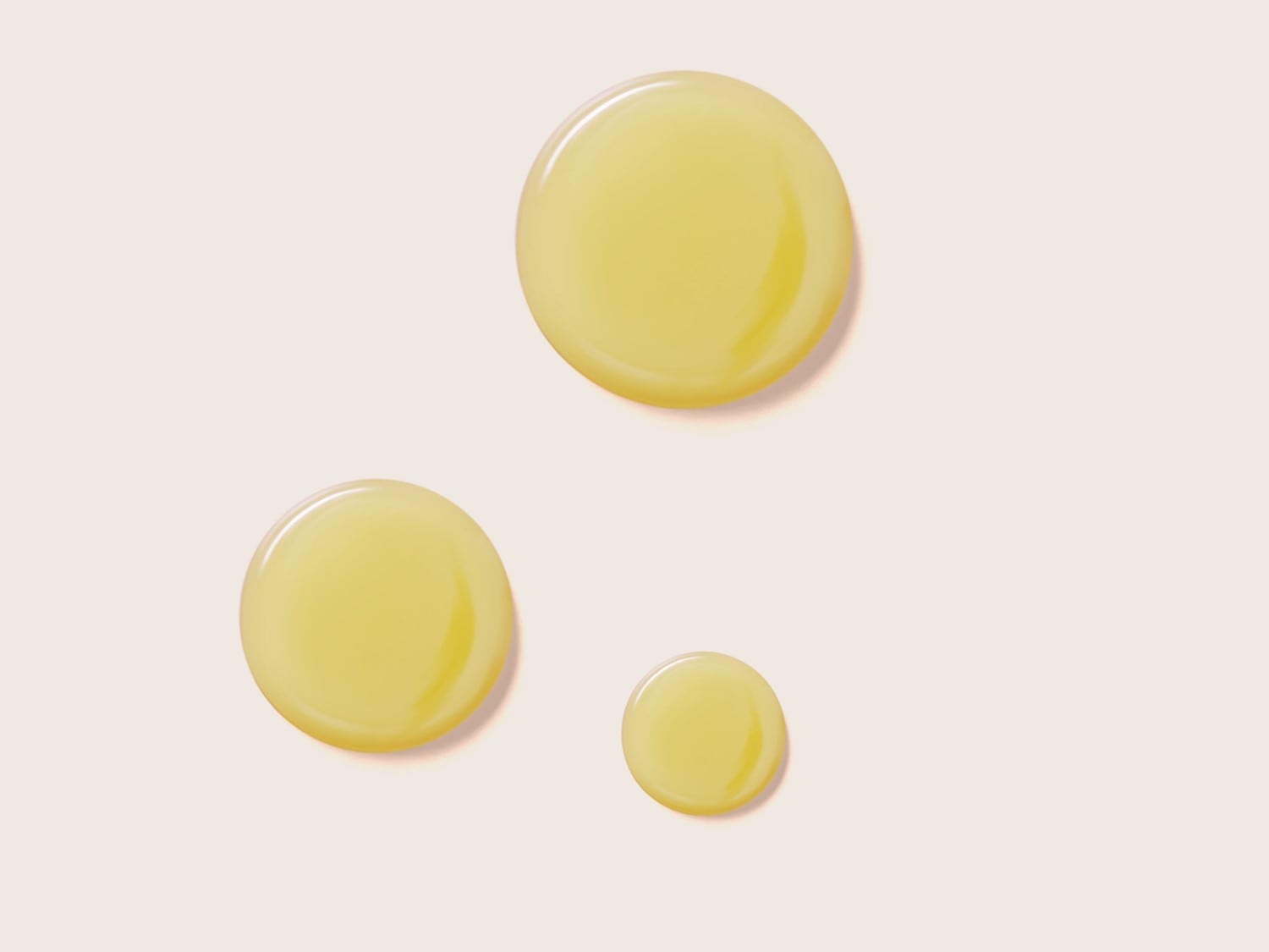 Gocce dorate di olio su sfondo chiaro, perfette per illustrare la texture ricca e nutriente di un prodotto di bellezza.