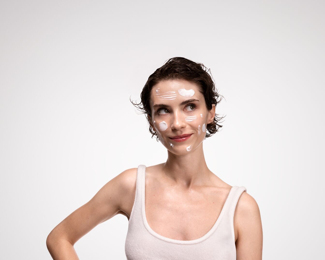 Primer plano del rostro de una mujer con piel clara, ojos grises y cejas bien definidas, resaltando una tez luminosa y labios sutilmente rosados.