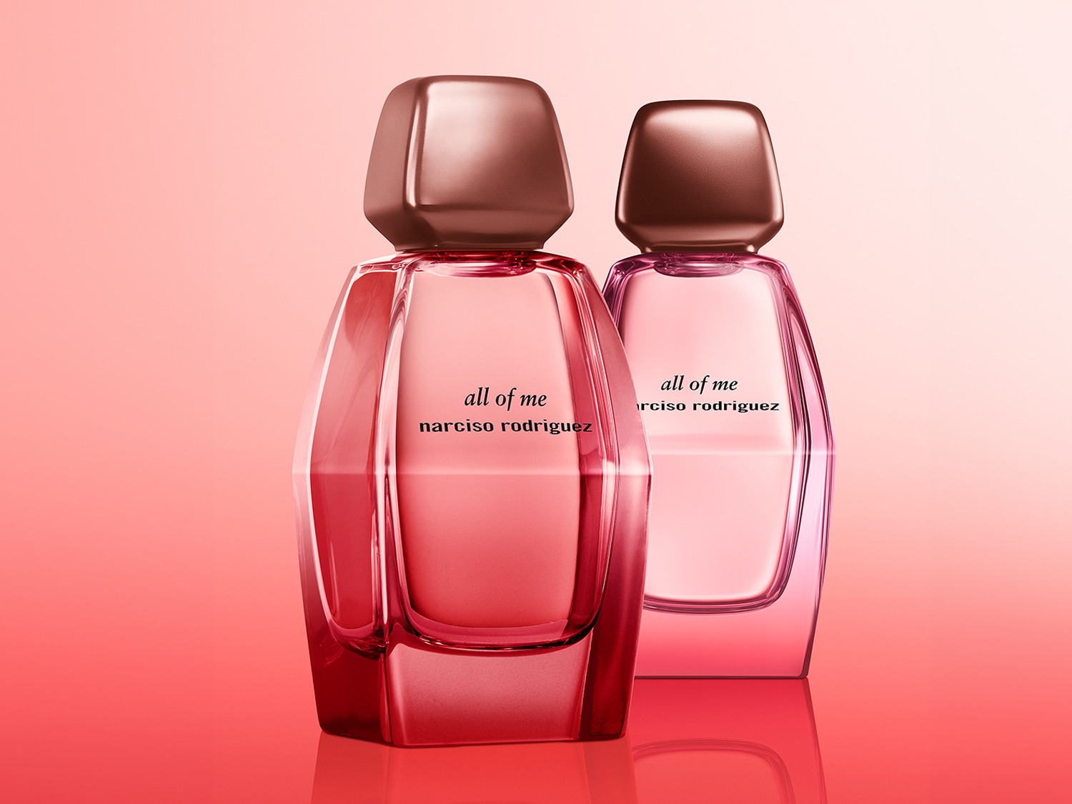 Dos frascos de perfume "All of Me" de Narciso Rodriguez, uno en tonos rosados intensos y otro en un rosa más suave, ambos con tapones metálicos cobrizos.