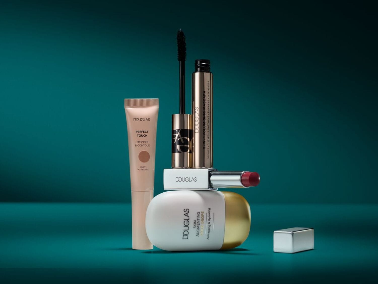 Kozmetika Douglas ponúka bronzer a kontúru Perfect Touch, 5 v 1 objemovú maskaru, rúž a pleťové sérum Skin Augmenting Gold Drops pre anti-aging a hydratáciu.