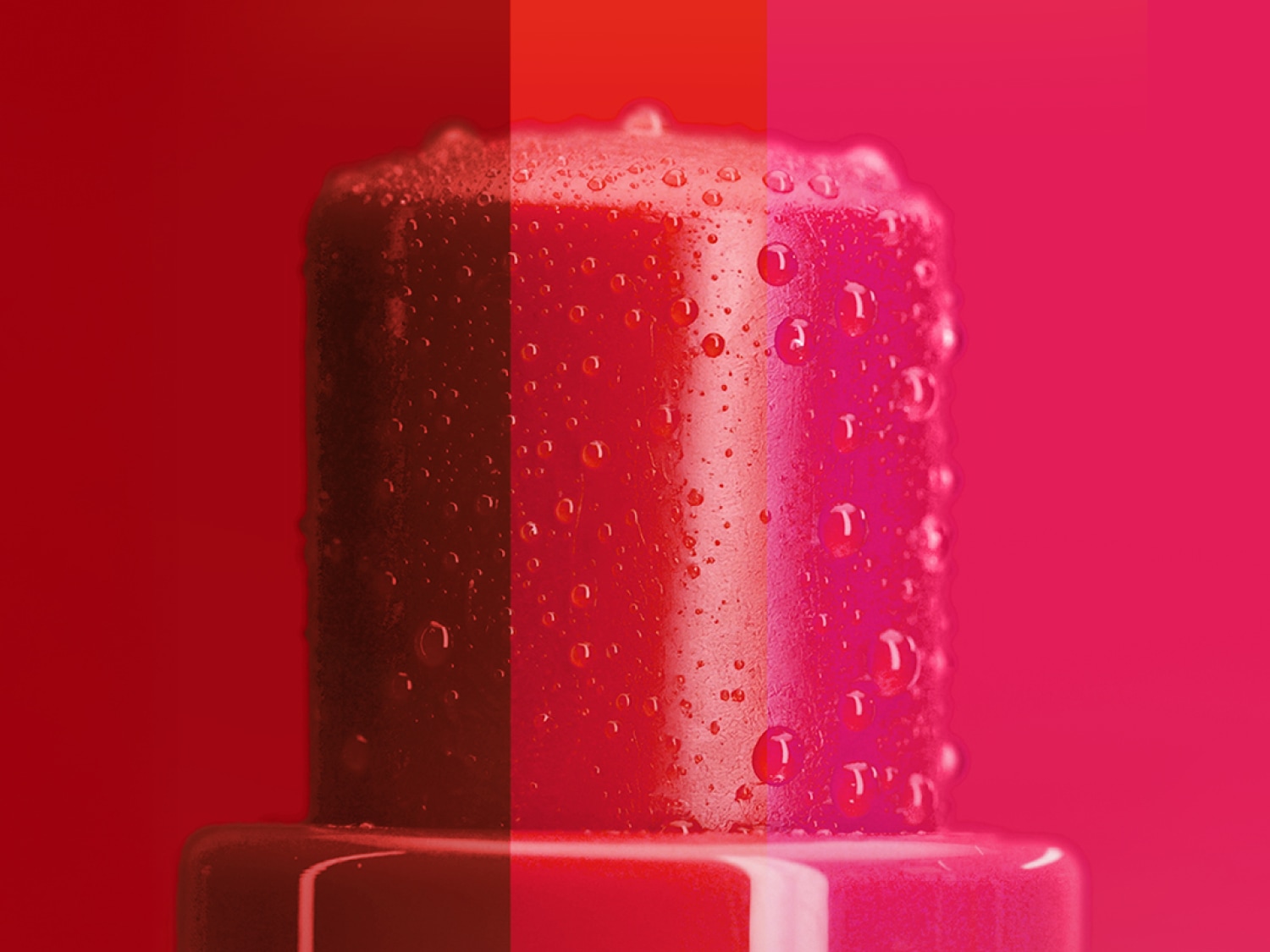 Primer plano de un envase rojo brillante con gotas de agua, resaltando su textura fresca e hidratante.