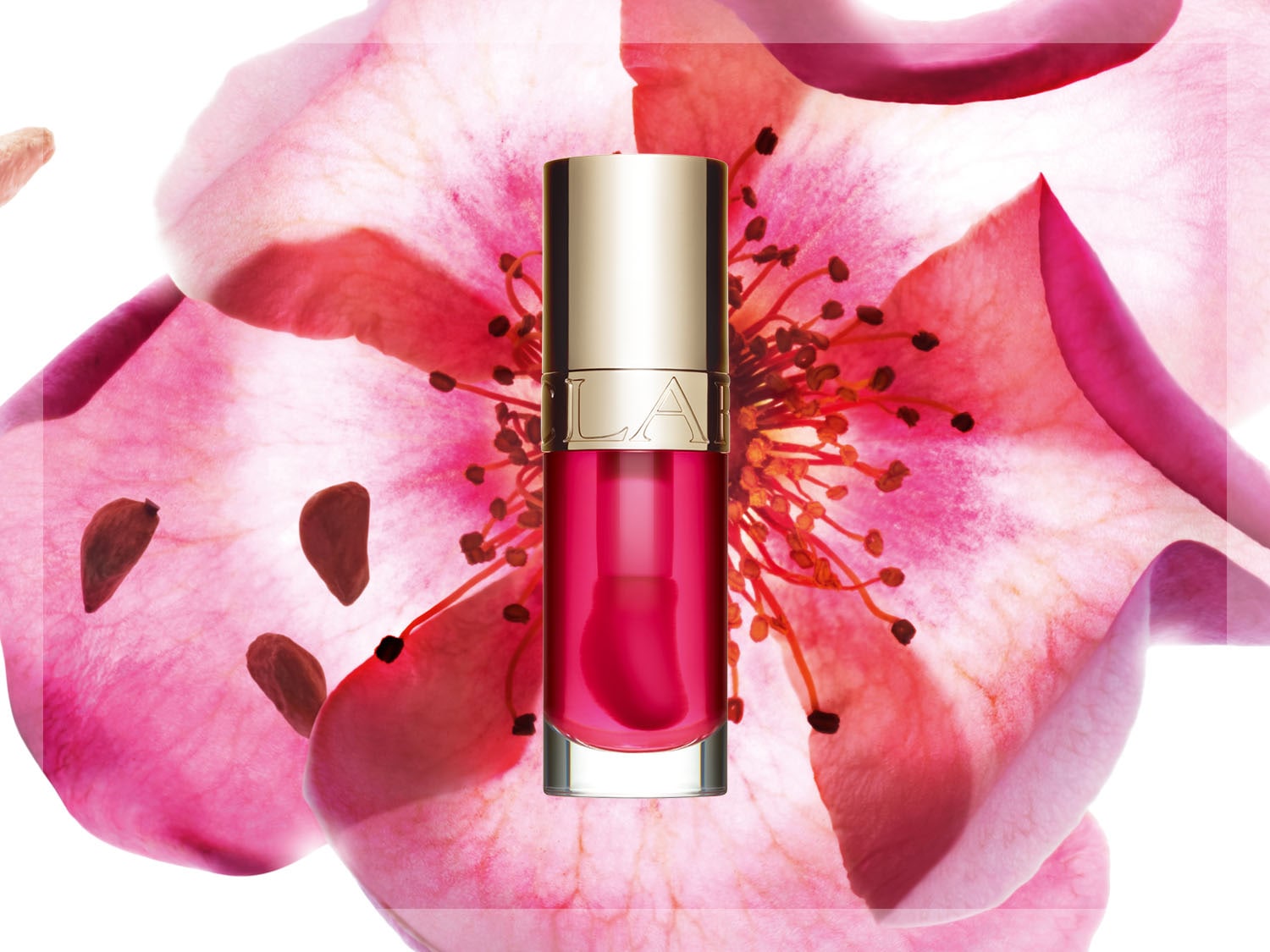 Lesk na rty Clarins v průhledné lahvičce s víčkem ve zlaté barvě, umístěný na pozadí růžového květu, který dodává produktu jemný a elegantní vzhled.