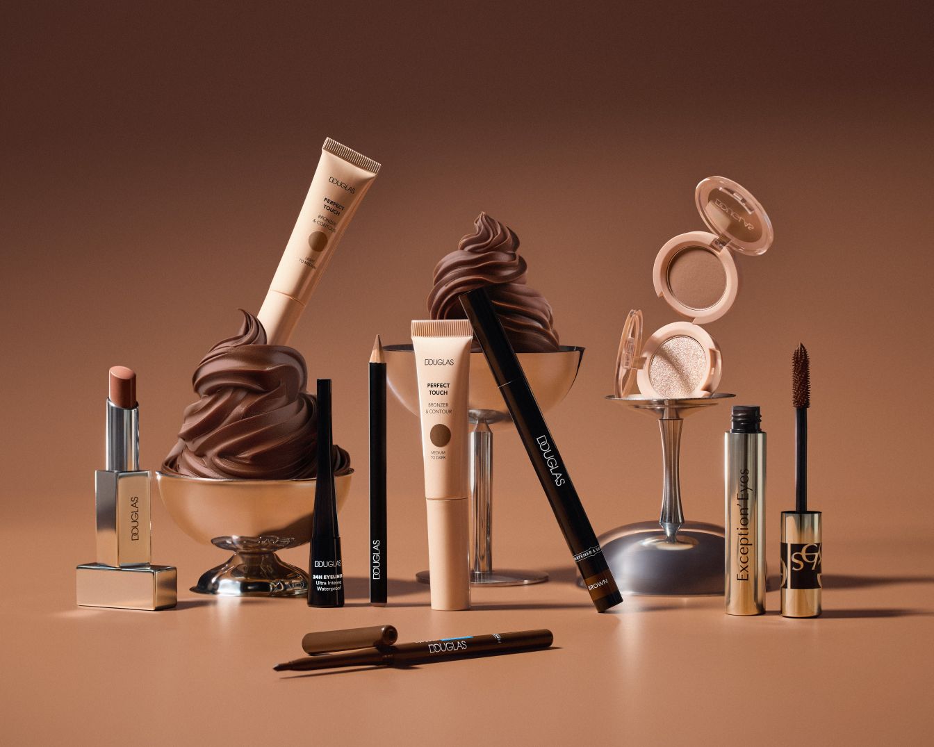 Eine Auswahl an Douglas Make-up Produkten in Braun- und Beigetönen, darunter Lippenstift, Concealer, Eyeliner und Mascara, die elegant auf einem passenden Untergrund präsentiert werden.