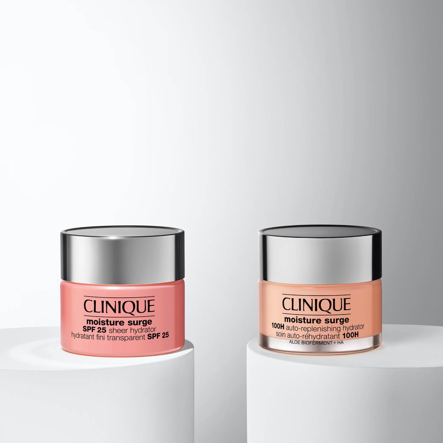 Zwei Tiegel Clinique Moisture Surge, der eine SPF 25 Sheer Hydrator in einem rosa Behälter, der andere 100H Auto-Replenishing Hydrator in einem pfirsichfarbenen Behälter.