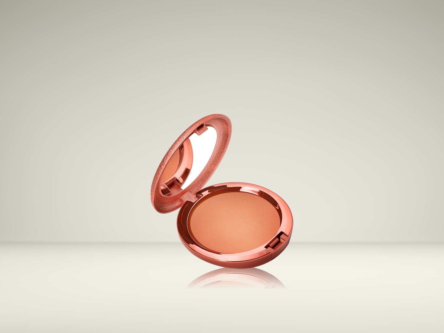 Een open, ronde blushdoos in een glanzende koraalkleur, met de blush zelf zichtbaar en een spiegel in het deksel.