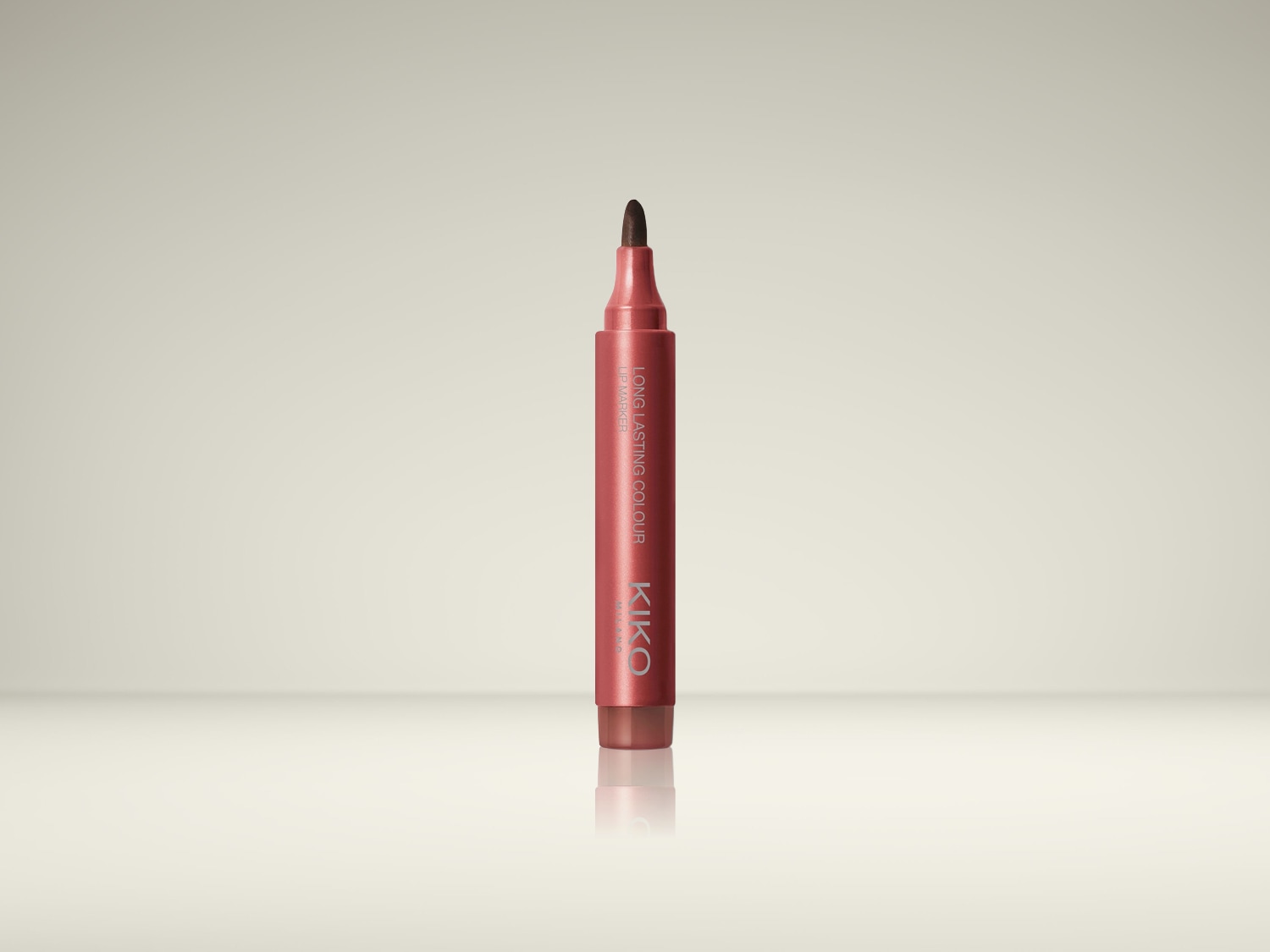 De Kiko Milano Long Lasting Colour Lip Marker in een roze tint, met een donkerbruine vilten punt, staat rechtop en is klaar voor gebruik.