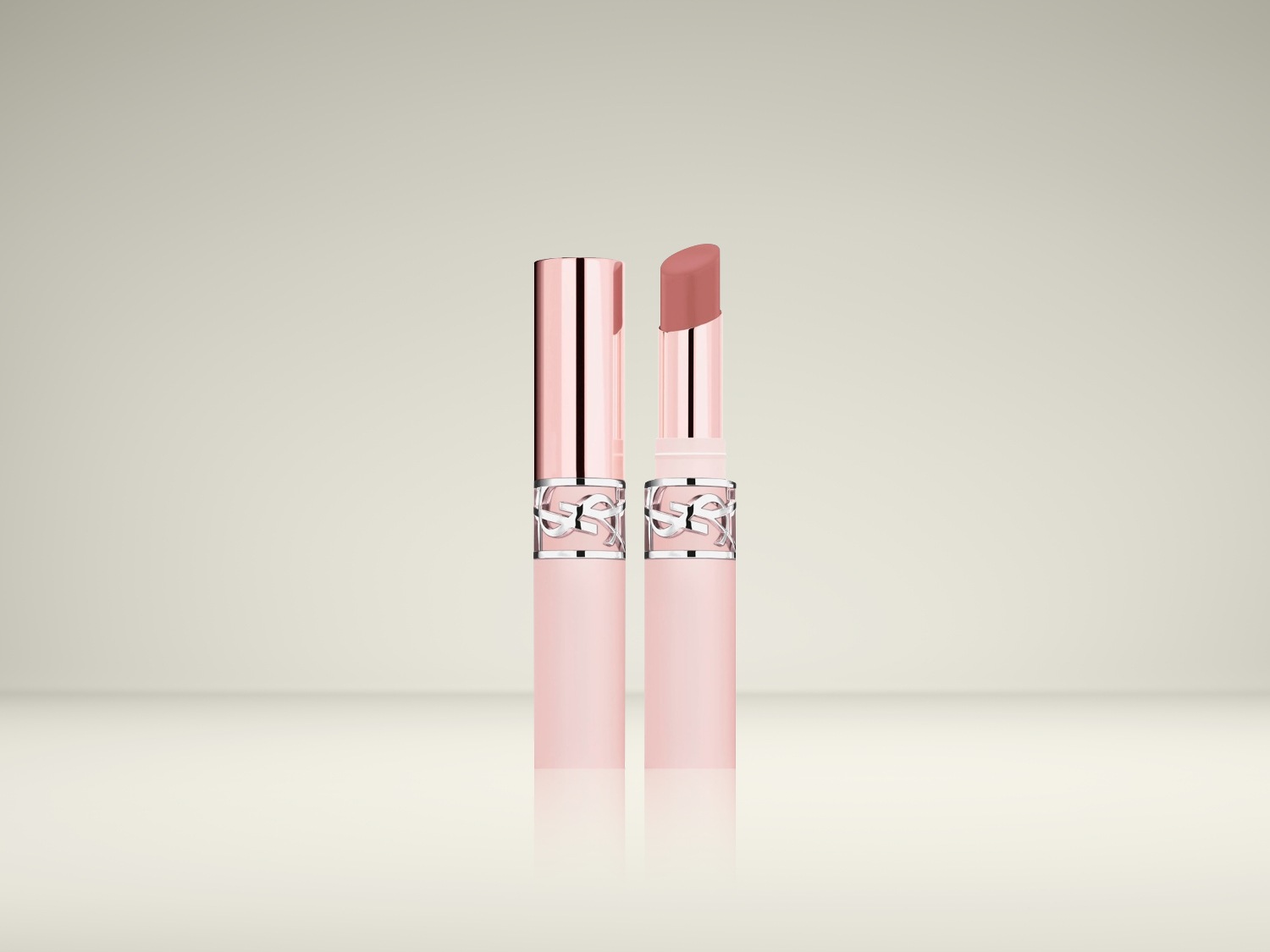Twee YSL lippenstiften, één gesloten met een roze dop en zilveren details, de andere open met een perzikkleurige tint.