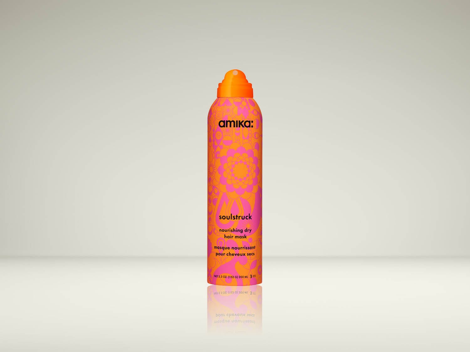 De Amika Soulstruck Nourishing Dry Hair Mask is een oranje spuitbus met roze bloemmotieven, ontworpen om droog haar te voeden en te hydrateren.