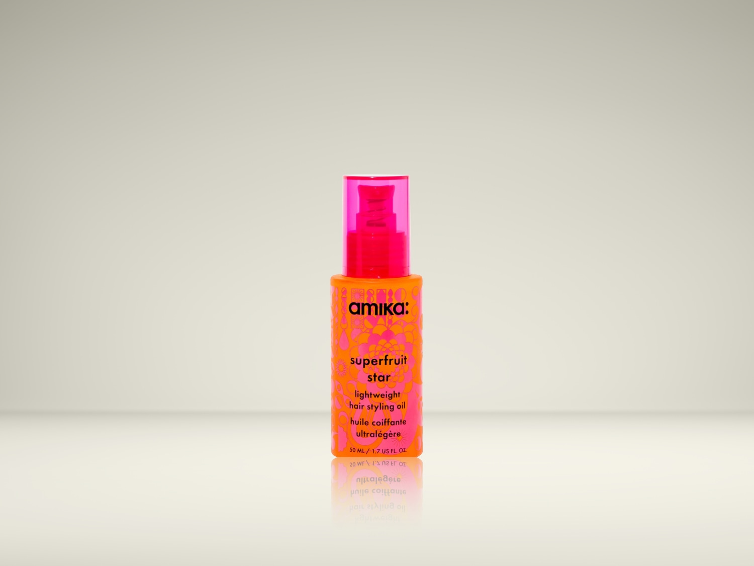 Oranje Amika superfruit star lichtgewicht haarstylingolie in een flesje met een roze pompje, ideaal voor een lichte en verzorgde styling.